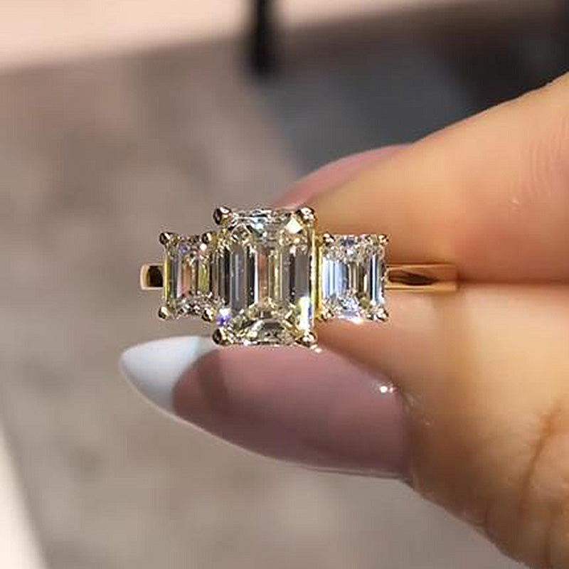 Stunning Golden Tone Emerald Cut Three Stone Engagement Ring In Sterling Silver